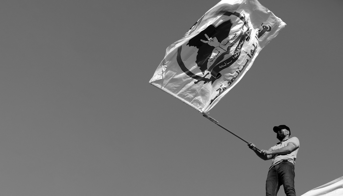 A supporter of Iran-backed Shiite militia Asaib Ahl al-Haq or 'League of the Righteous' waving its flag in Baghdad, Iraq, 14 July 2023.  