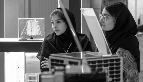 Two young female Iranian scientists stand together at the booth of the Iranian Space Research Center during an aerospace exhibition in Tehran, Iran, on 11 February 2025. 