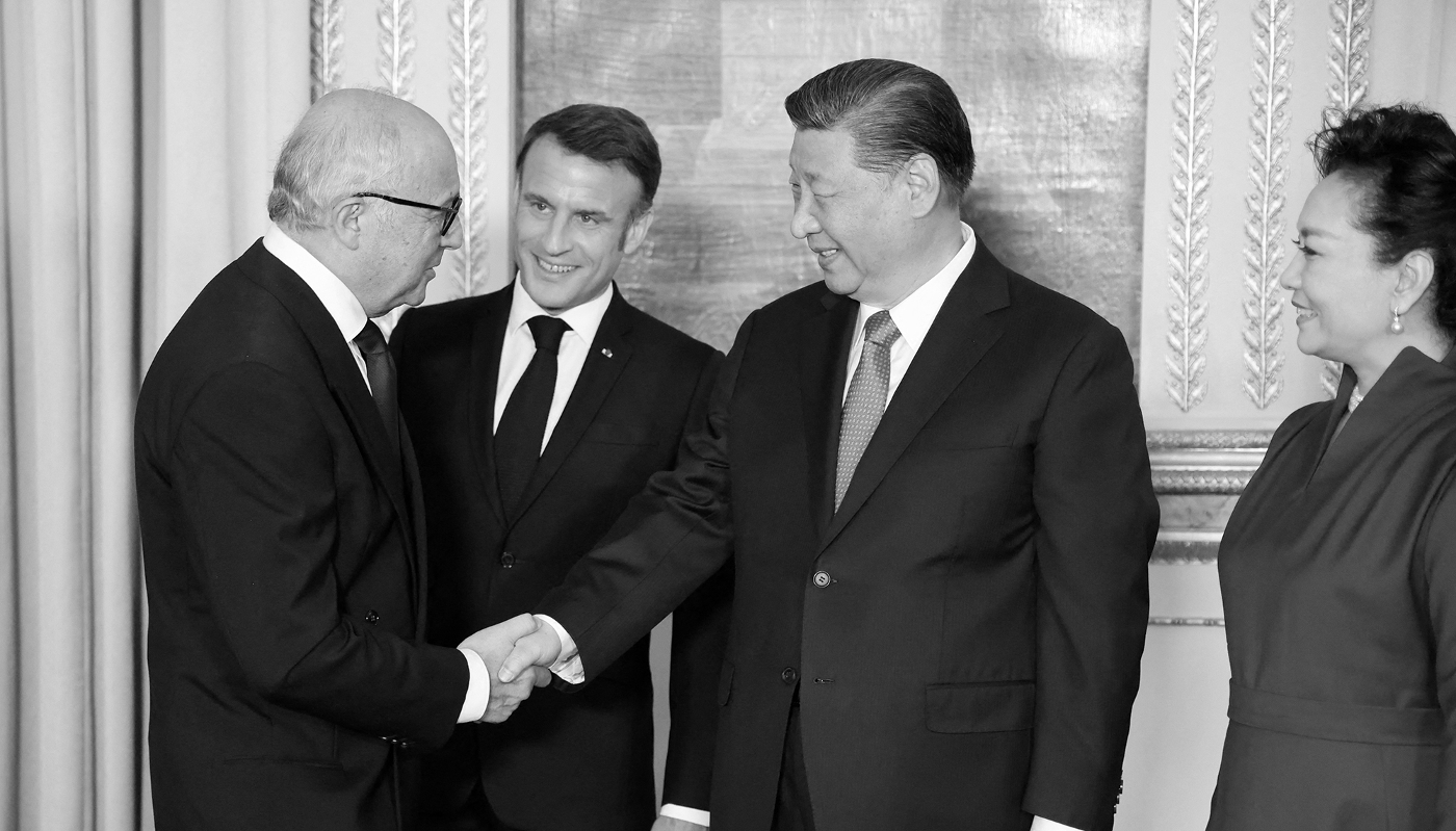 French ex-prime minister Laurent Fabius (L) shakes hands with Chinese President Xi Jinping in the presence of French President Emmanuel Macron (C) ahead of an official state dinner at the presidential Elysée palace in Paris, France, on 6 May 2024.