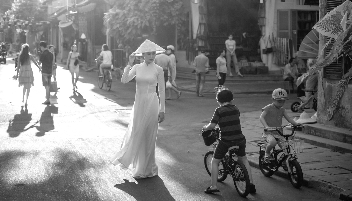 A lady in traditional áo dài on a street in Hoi An, Vietnam.