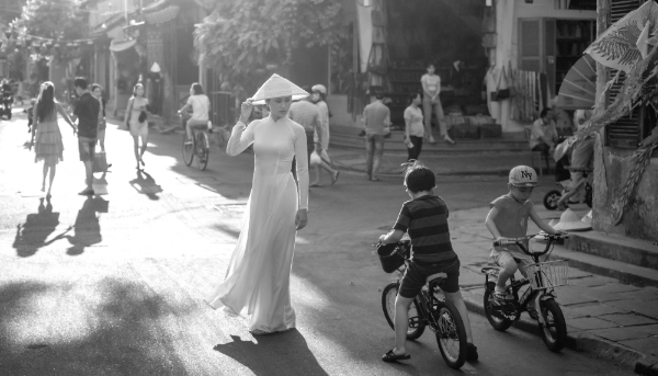 A lady in traditional áo dài on a street in Hoi An, Vietnam.
