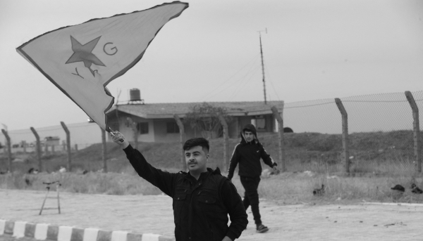 A Syrian Kurd waves a YPG flag near Qamishli airport in northeastern Syria on 8 December 2024.