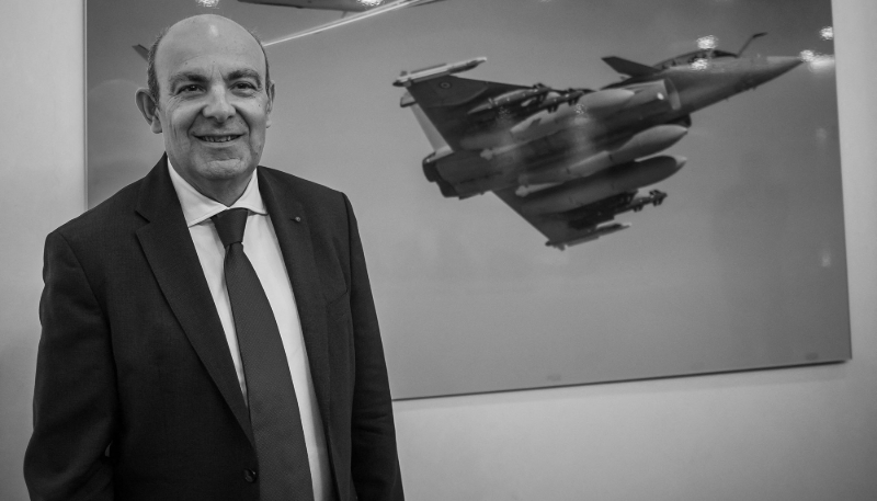 Éric Trappier, Chief Executive Officer of Dassault Aviation Group, poses next to a poster depicting a Rafale fighter jet on 4 March 2022. 

