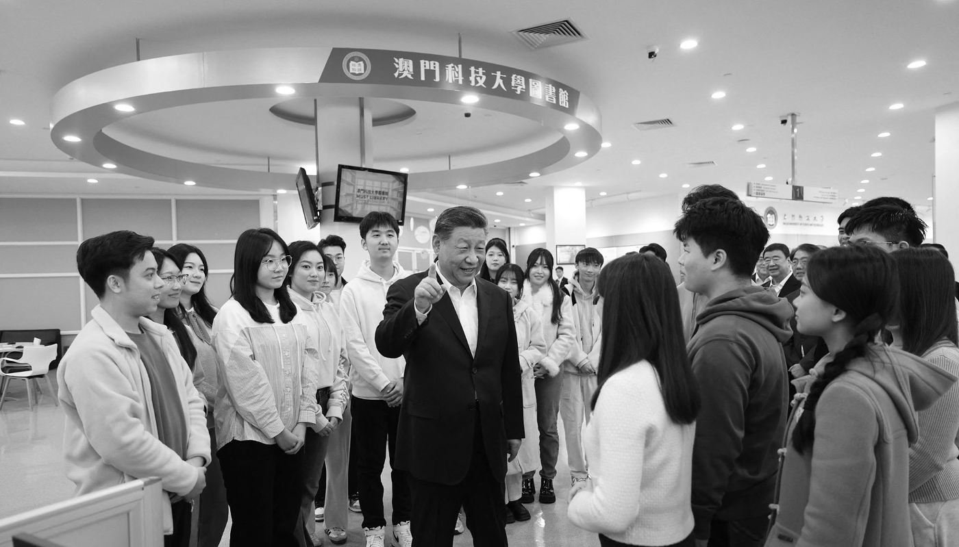 Chinese President Xi Jinping talks with students in the library of Macau University of Science and Technology (MUST) in southern China, on 19 December 2024.